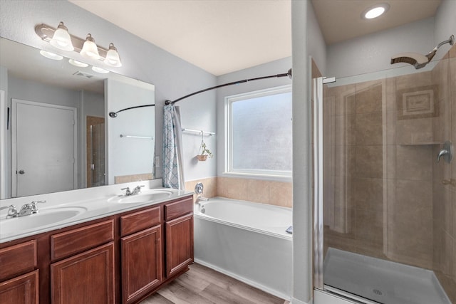 bathroom with hardwood / wood-style floors, vanity, and independent shower and bath