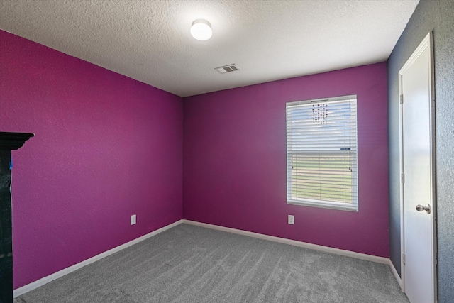 carpeted spare room with a textured ceiling