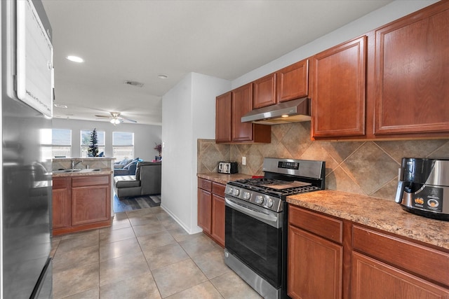 kitchen with decorative backsplash, appliances with stainless steel finishes, ceiling fan, sink, and light tile patterned floors