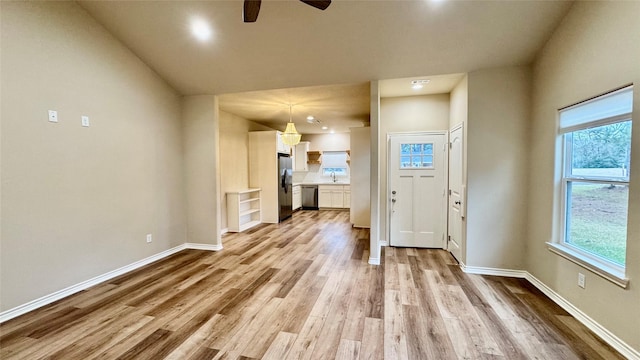 unfurnished living room with light hardwood / wood-style floors, sink, and ceiling fan