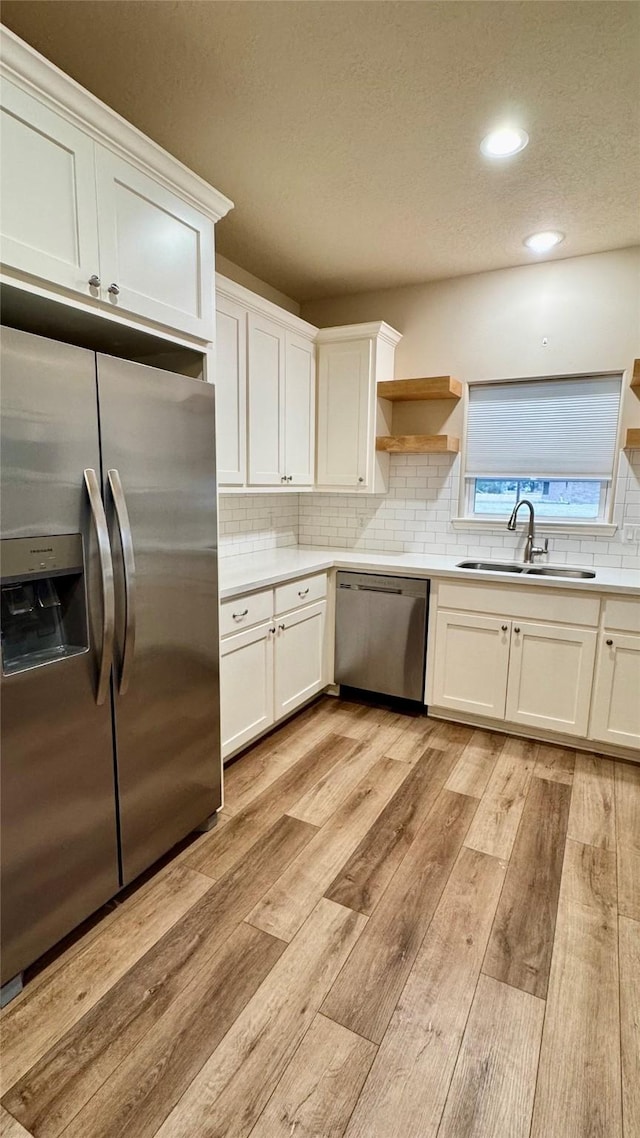 kitchen featuring light hardwood / wood-style floors, sink, white cabinets, and stainless steel appliances