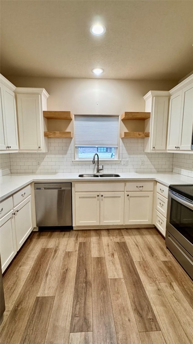 kitchen featuring stainless steel appliances, white cabinetry, and sink