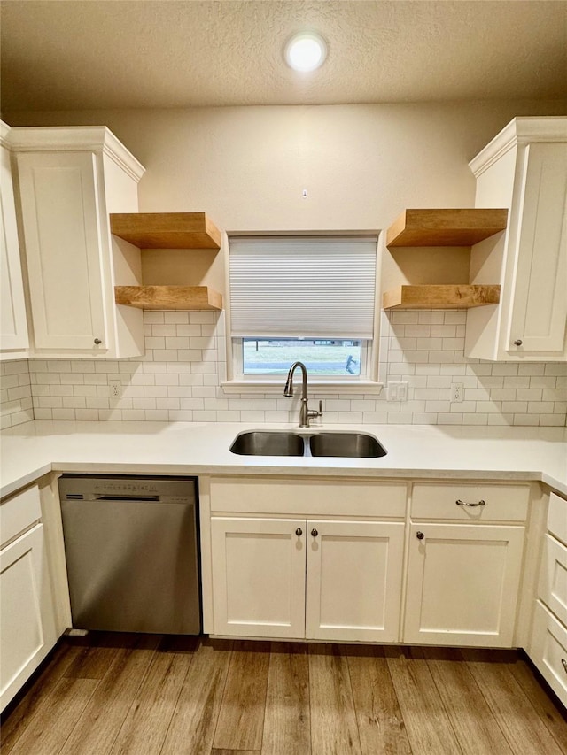 kitchen featuring dishwasher, white cabinets, and sink