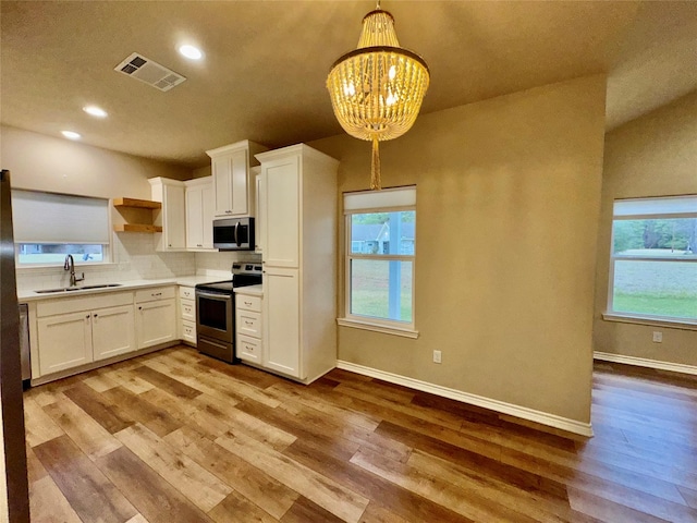 kitchen featuring an inviting chandelier, white cabinetry, stainless steel appliances, decorative light fixtures, and sink