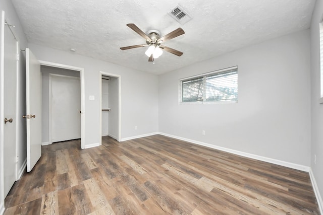 unfurnished bedroom featuring ceiling fan, dark hardwood / wood-style flooring, and a textured ceiling