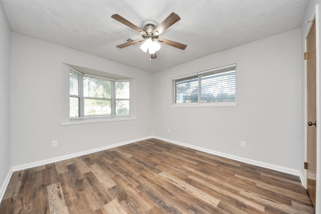 empty room featuring ceiling fan and dark wood-type flooring