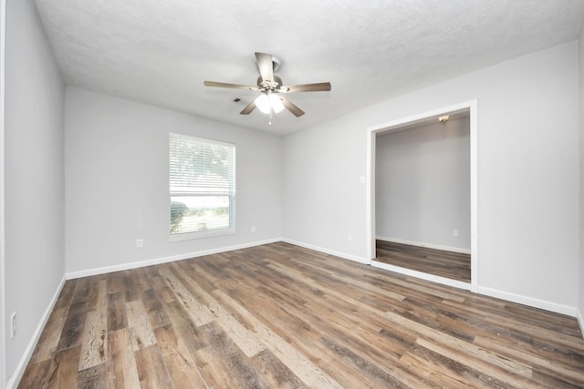 unfurnished room featuring ceiling fan, hardwood / wood-style floors, and a textured ceiling