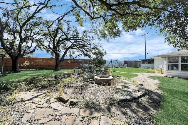 view of yard with a sunroom and a fire pit