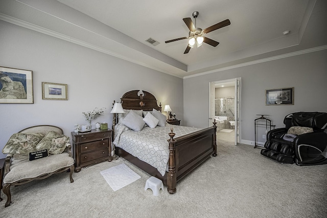 carpeted bedroom with connected bathroom, a tray ceiling, ceiling fan, and ornamental molding