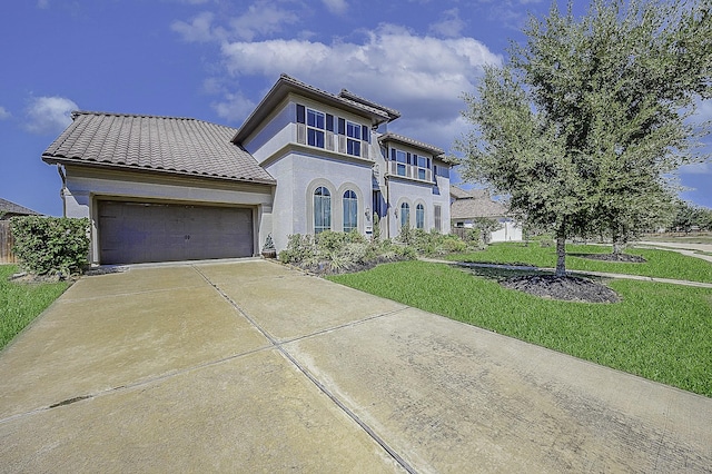 mediterranean / spanish home featuring a front lawn and a garage