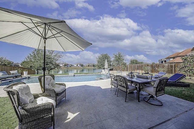 view of patio featuring a water view and a fenced in pool