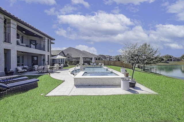 view of pool featuring a patio, a water view, and a lawn