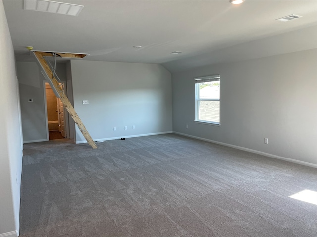 carpeted spare room with lofted ceiling