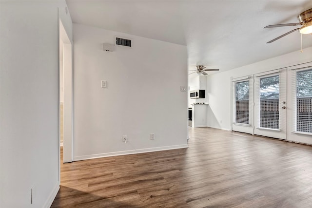 unfurnished living room featuring ceiling fan, hardwood / wood-style floors, and french doors