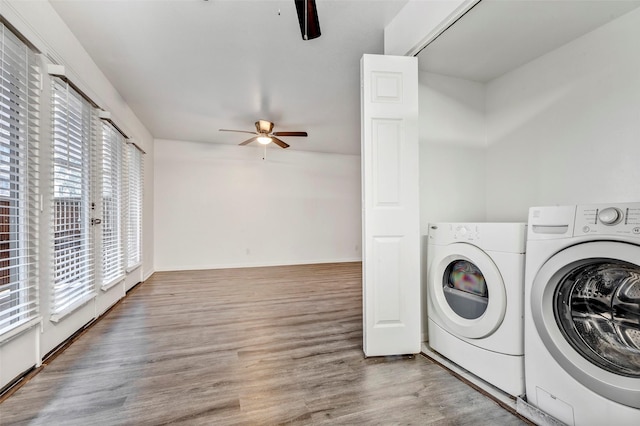 clothes washing area featuring wood-type flooring, washing machine and dryer, and ceiling fan