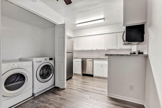 laundry area featuring light wood-type flooring, washer and clothes dryer, and ceiling fan