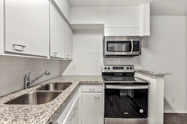 kitchen featuring light stone countertops, white cabinetry, sink, and appliances with stainless steel finishes