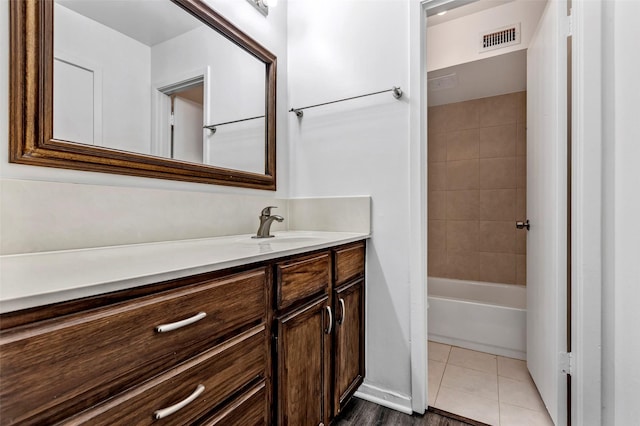 bathroom with tile patterned floors, vanity, and tiled shower / bath