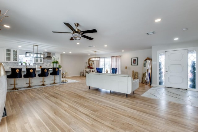 living room with ceiling fan and light hardwood / wood-style flooring