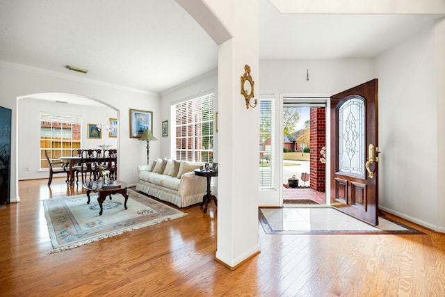 entrance foyer with ornamental molding and light wood-type flooring