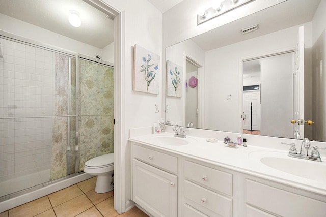 bathroom with vanity, a tile shower, tile patterned floors, and toilet