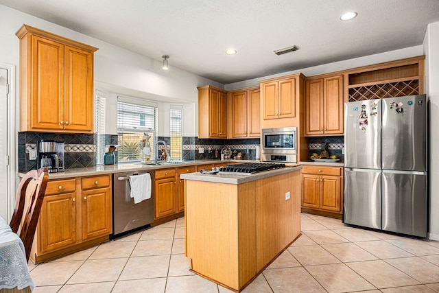 kitchen featuring a kitchen island, appliances with stainless steel finishes, tasteful backsplash, sink, and light tile patterned floors