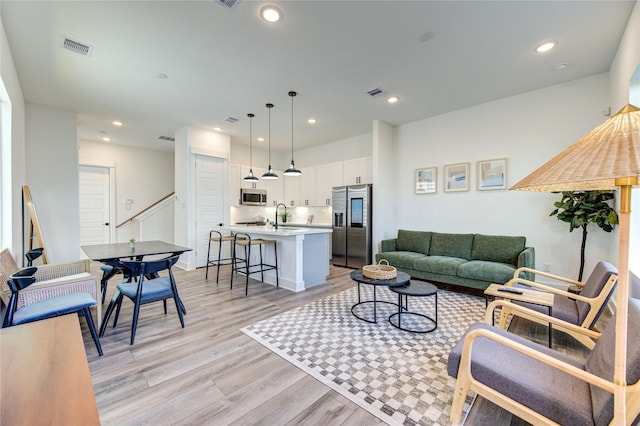 living room with sink and light hardwood / wood-style floors