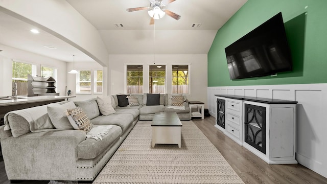 living room with hardwood / wood-style flooring, vaulted ceiling, ceiling fan, and sink