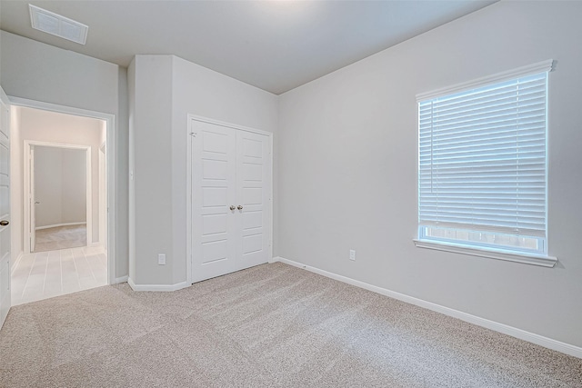 unfurnished bedroom featuring carpet floors and a closet