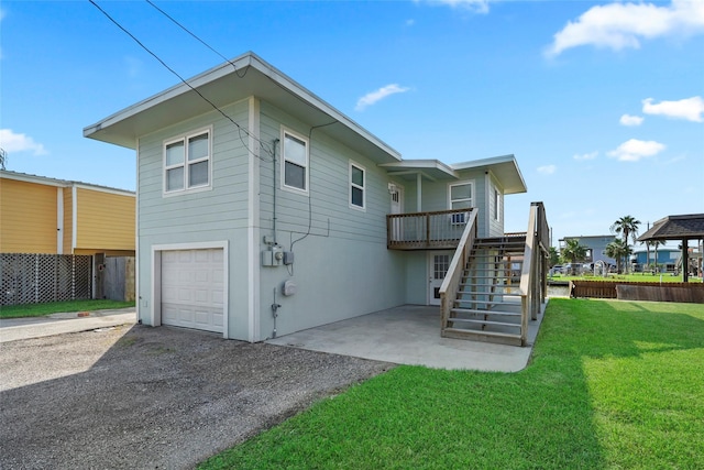 rear view of property with a garage and a lawn