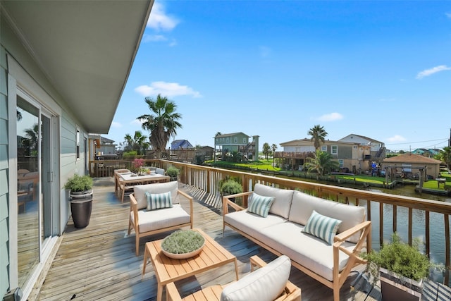 wooden deck featuring an outdoor living space and a water view