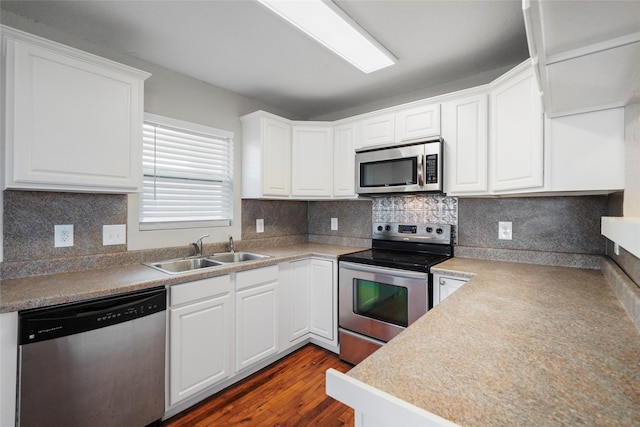 kitchen featuring white cabinetry, sink, dark wood-type flooring, and appliances with stainless steel finishes