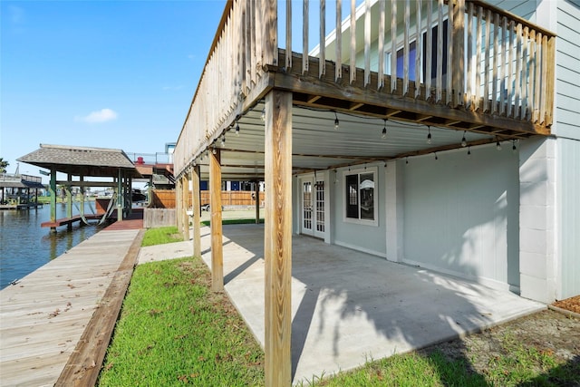 dock area with a water view and a patio