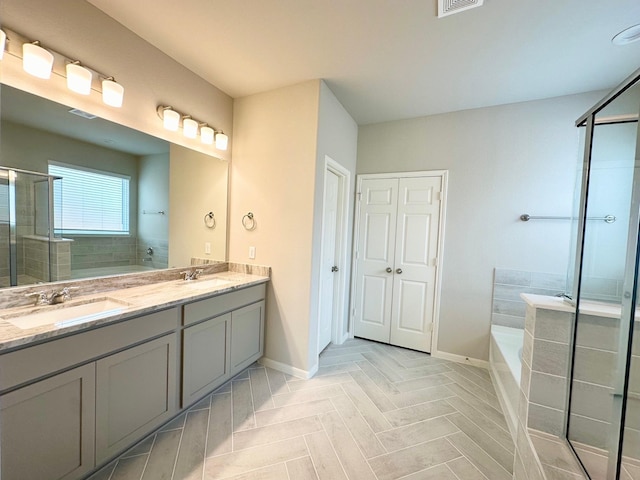 bathroom featuring vanity and shower with separate bathtub