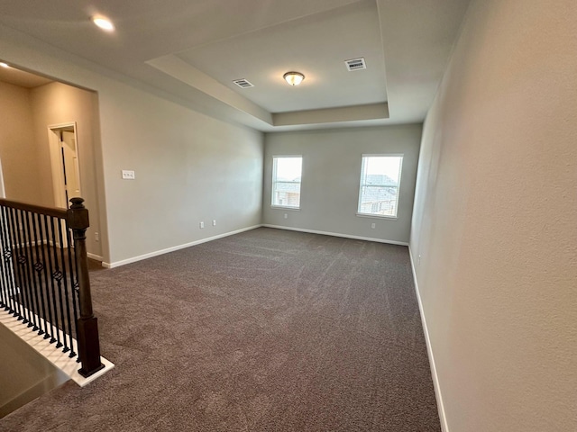 carpeted spare room with a tray ceiling