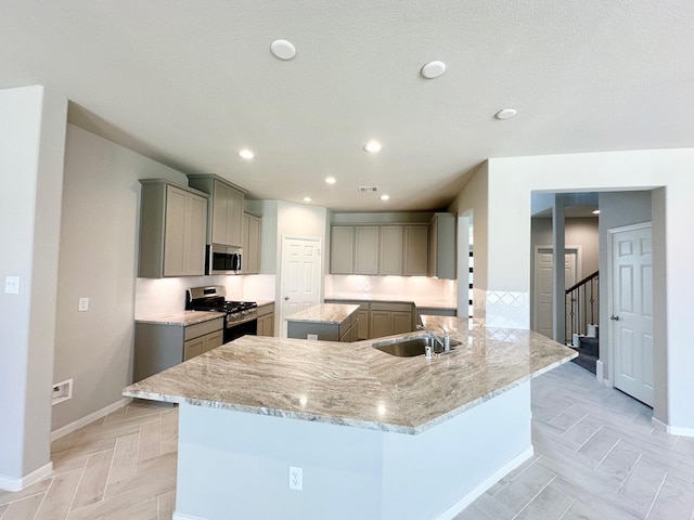 kitchen featuring gray cabinets, kitchen peninsula, sink, and appliances with stainless steel finishes