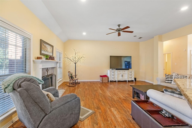 living room featuring ceiling fan, light wood-type flooring, and vaulted ceiling