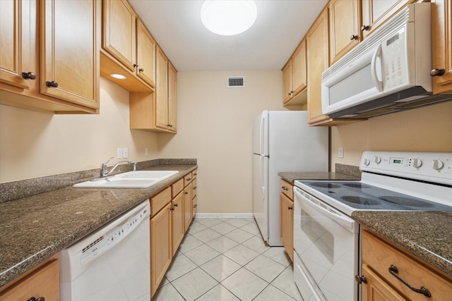 kitchen with white appliances, sink, light tile patterned floors, and dark stone counters