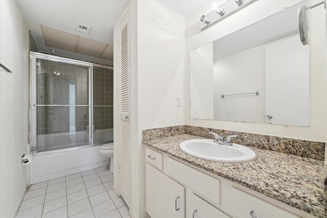 bathroom featuring tile patterned flooring, vanity, and bath / shower combo with glass door