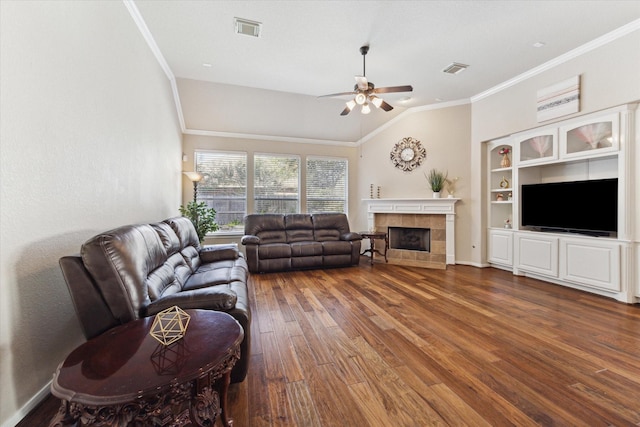 living room featuring vaulted ceiling, ceiling fan, ornamental molding, a fireplace, and dark hardwood / wood-style flooring