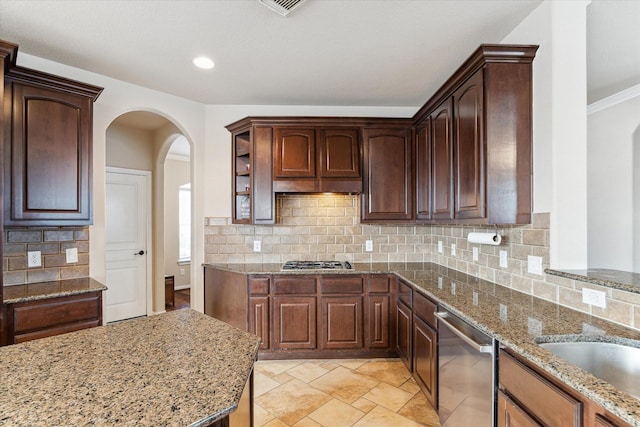 kitchen with decorative backsplash, light stone counters, sink, and appliances with stainless steel finishes