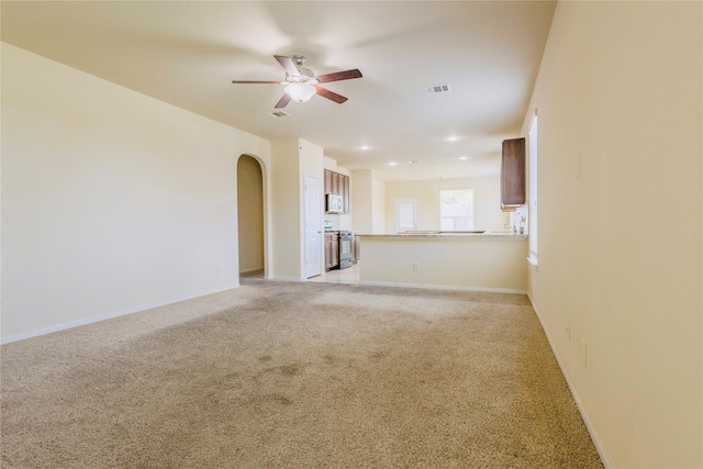 unfurnished living room with light carpet and ceiling fan