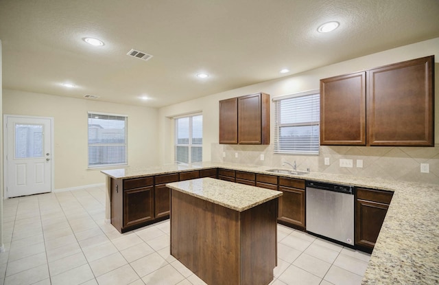 kitchen featuring stainless steel dishwasher, tasteful backsplash, light stone countertops, a center island, and dark brown cabinetry