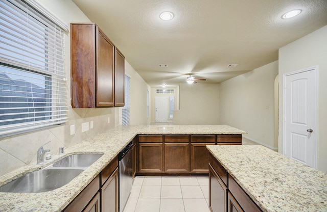 kitchen with sink, light stone countertops, stainless steel dishwasher, and tasteful backsplash