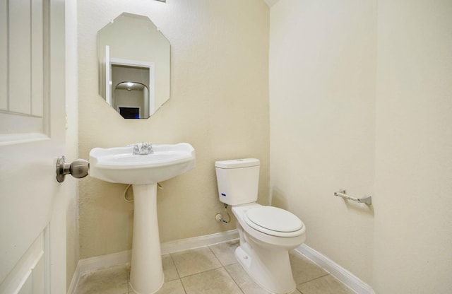 bathroom featuring toilet and tile patterned flooring