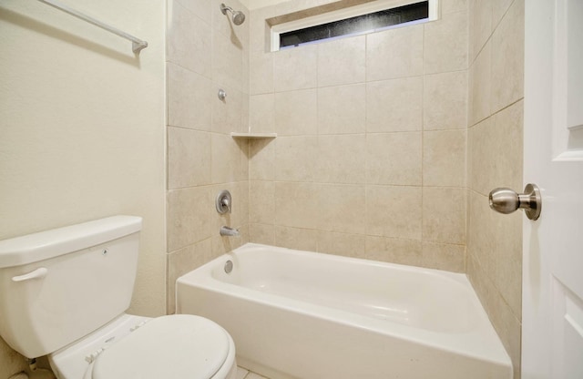 bathroom featuring toilet and tiled shower / bath combo