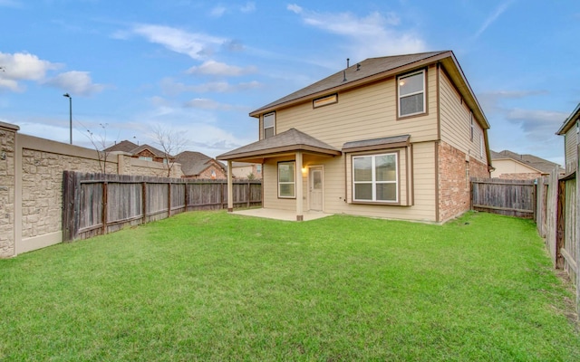 back of property with a yard and a patio