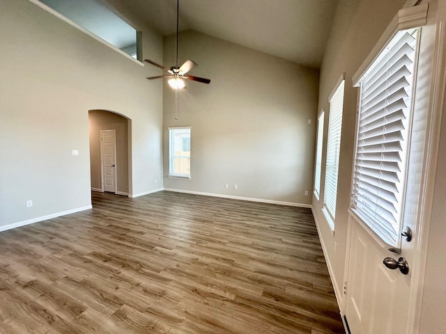 spare room with wood-type flooring, high vaulted ceiling, and ceiling fan