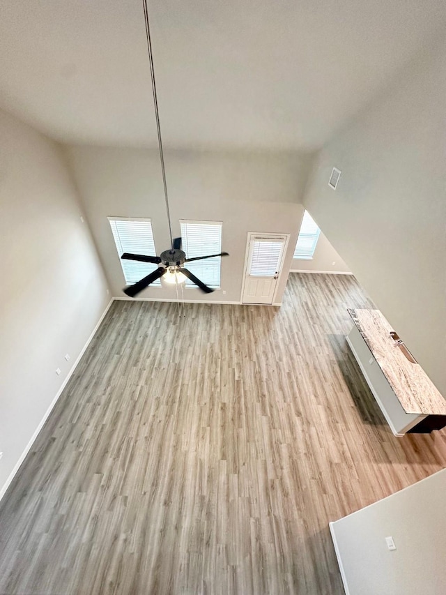 unfurnished living room featuring ceiling fan and light hardwood / wood-style floors