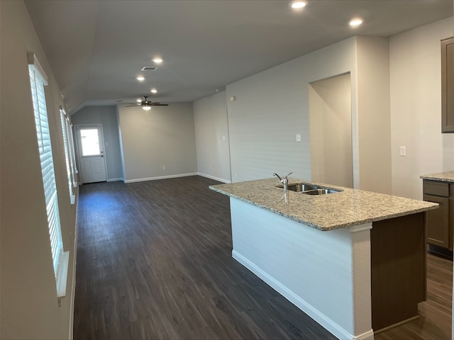 kitchen featuring vaulted ceiling, ceiling fan, sink, dark hardwood / wood-style floors, and an island with sink